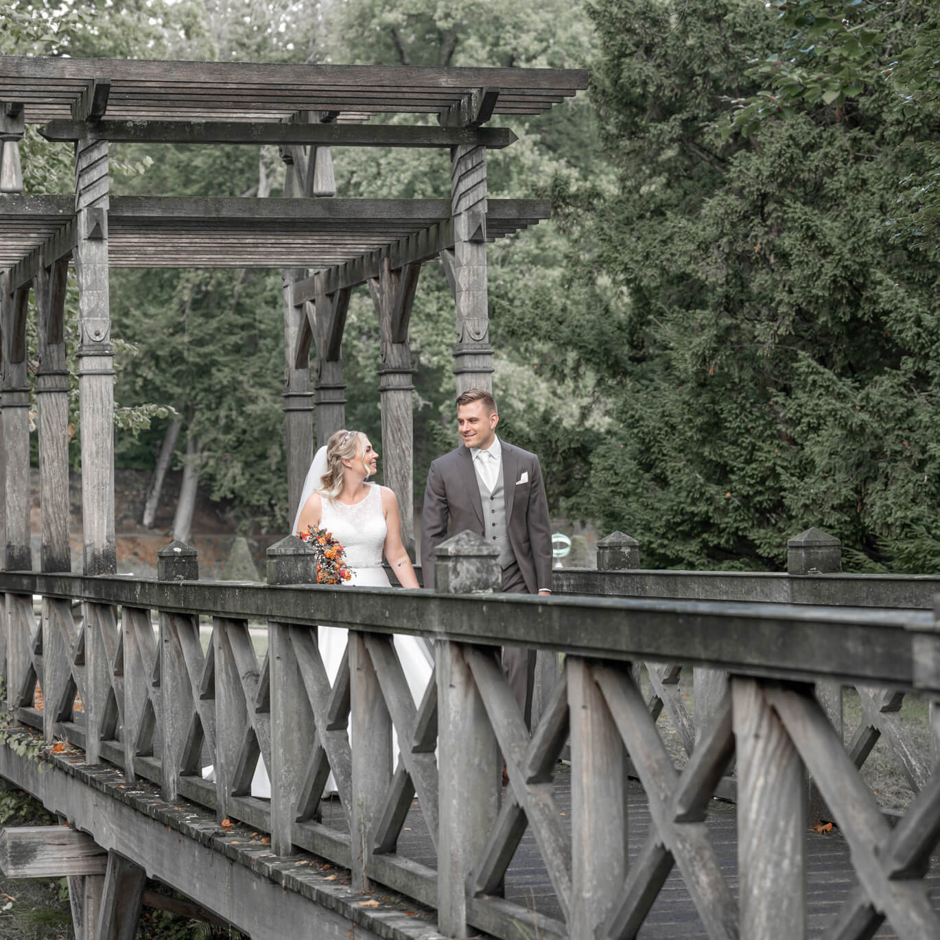 Bruispaar loopt op een houten brug in Clingendael.