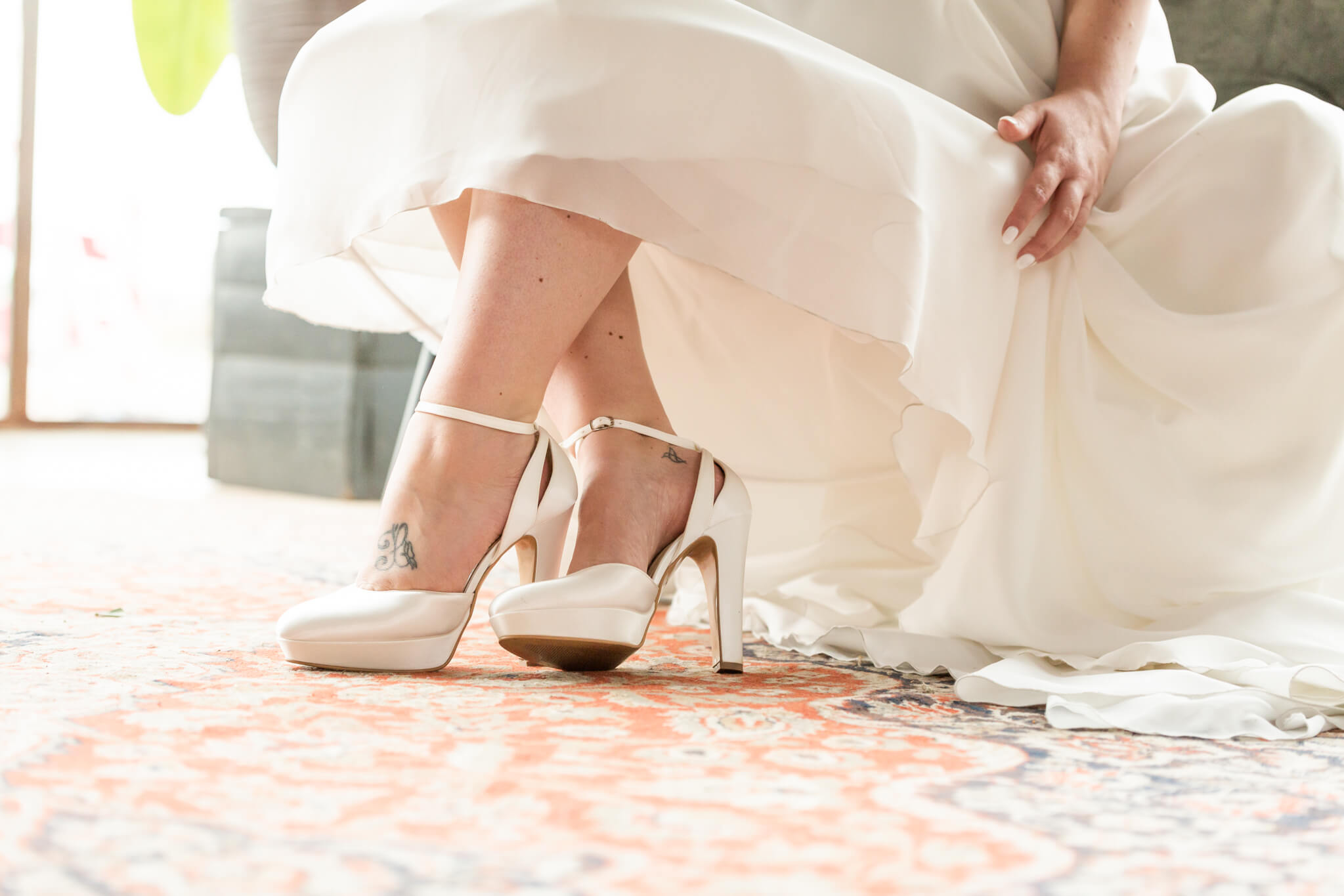 Schoenen van de bruid. Detailfoto van de bruidschoen en een stukje bruidsjurk.